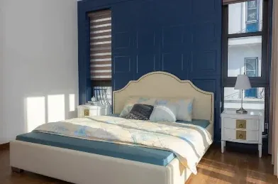 Hotelzimmer mit blauem Kopfteil und gemachtem Bett